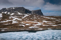 Snowy landscape of Hardangervidda with mountains and icy lake in Norway by Bastian Linder