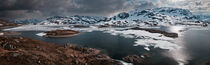 Snowy landscape of Hardangervidda with mountains and icy lakes in Norway by Bastian Linder
