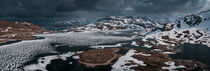 Snowy landscape of Hardangervidda with mountains and icy lakes in Norway by Bastian Linder