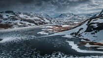 Snowy landscape of Hardangervidda with mountains and icy lakes in Norway von Bastian Linder
