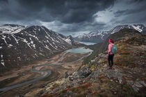 Girl hiking along turquoise lakes and river in mountain landscape from above the hike to Knutshoe summit in Jotunheimen National Park in Norway von Bastian Linder
