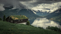 Grass roof house over the Nordfjord fjord with mountains in summer in Norway by Bastian Linder