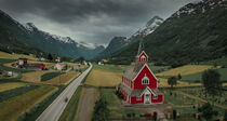 Red wooden church of Olden with road in the fjord Nordfjord in summer in Norway from above von Bastian Linder