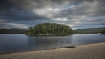 Sand beach with boat and trees on lake in Sorlandet Norway under dramatic sky by Bastian Linder