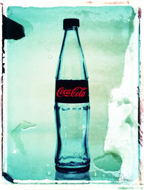 Eine leere Coca Cola Flasche auf hellblauem Untergrund by Gerhard Bumann