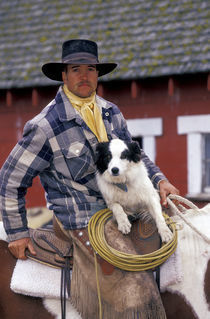 N.A., USA, Oregon, Seneca, Ponderosa Ranch Cowboy in saddle with dog von Danita Delimont