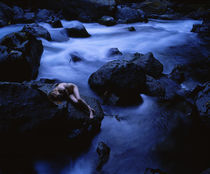 High angle view of a teenage girl lying naked on a rock by Panoramic Images