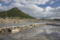 Salt ponds with a village and mountain in the background by Panoramic Images