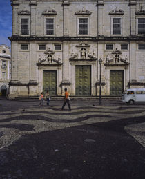 Three people walking in front of a building by Panoramic Images