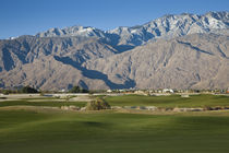 Golf course with mountain range by Panoramic Images