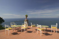 Empty tables and chairs on the balcony of a hotel by Panoramic Images