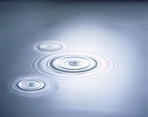 Three rings in grey tinted water with bright light by Panoramic Images