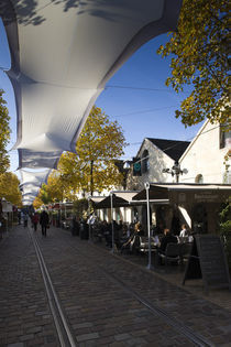 People at sidewalk cafes by Panoramic Images