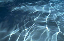 Shiny light strings in blue water by Panoramic Images