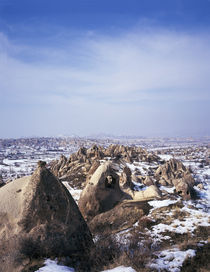 Cliff dwellings in a snow covered field by Panoramic Images