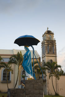 Statue of Virgin Mary with parasol in front of a church by Panoramic Images