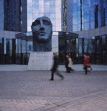 Statue of a human face in front of a building, La Defense, Paris, France by Panoramic Images
