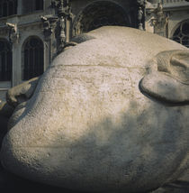 Close-up of a stone sculpture of a human head in front of a building by Panoramic Images