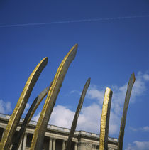 Low angle view of metal sculpture in front of a building by Panoramic Images
