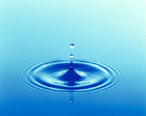 Drops rising from ripples in blue water von Panoramic Images