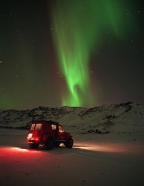 Jeep in a snow covered field with Aurora Borealis in the sky by Panoramic Images