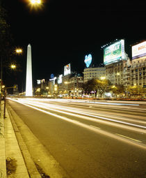 Obelisk lit up at night in a city by Panoramic Images