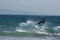 Kite surfer jumping over a wave, Playa de los Lances, Tarifa, Spain.