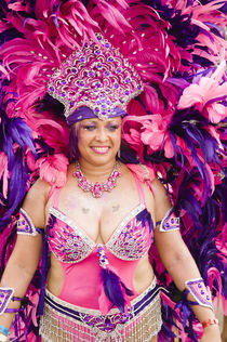 Woman in a pink and purple feathered costume in the Port of Spain carnival in Trinidad. by Tom Hanslien