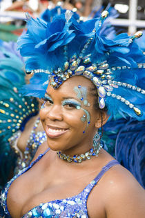 Woman in a blue feathered costume in the Port of Spain carnival in Trinidad. by Tom Hanslien