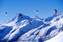 Snowboarder jumping next to helicopters. von Ross Woodhall