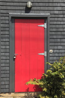 rote Tür in Wand mit Holzschindeln von Willy Matheisl