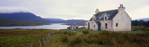 Farm house on bluff, mountains in mist, Isle of Lewis, Scotland. by Panoramic Images