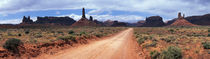 Dirt road through desert landscape with sandstone formations, Utah. by Panoramic Images