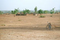 Bicycle and houses outside Béguédo, Burkina Faso by Palle Smith-Petersen
