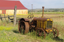 Rusty vintage tractor in field von Danita Delimont