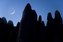 Crescent moon and silhouette of rocks by Danita Delimont