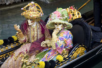 Couple dressed in costumes for the annual Carnival festival enjoy gondola ride by Danita Delimont