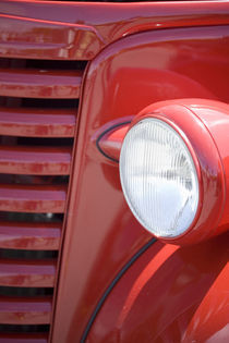 Headlight and partial grill of a red antique truck von Danita Delimont