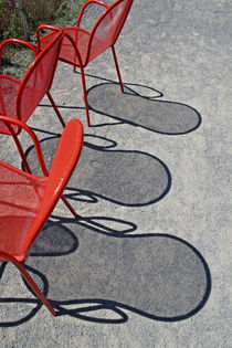 Red wire chairs shadows on concrete by Danita Delimont