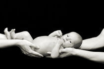 Naked baby in parents hands by Waldek Dabrowski