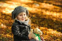 Little girl in autumn leaves by Waldek Dabrowski