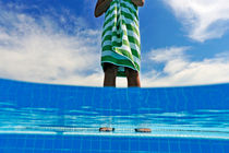Woman standing on swimming pool ledge by Sami Sarkis Photography