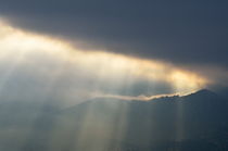 Sunbeams through clouds on mountains by Sami Sarkis Photography