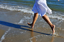 Woman running in water on beach by Sami Sarkis Photography