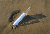 SOS message in bottle in sand by Sami Sarkis Photography