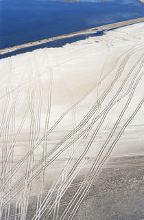 Car tracks on white sand beach by Sami Sarkis Photography