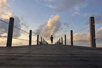 Woman running on wooden jetty at sunrise von Sami Sarkis Photography