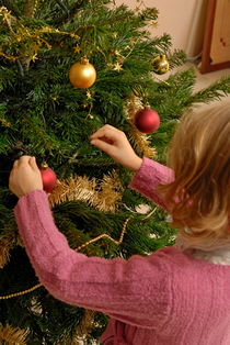 Girl decorating Christmas tree von Sami Sarkis Photography