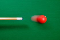 Pool cue striking red ball by Sami Sarkis Photography