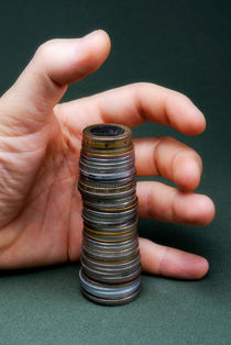 Hand surrounding stack of coins von Sami Sarkis Photography